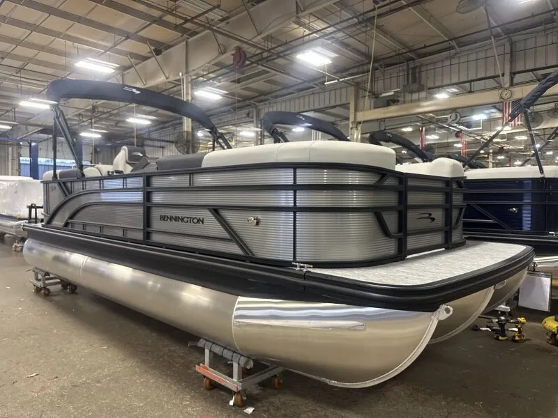Slide: The Image of A Bennington 22 S1 Stern Radius pontoon boat is in a warehouse. It features a modern design. - 6