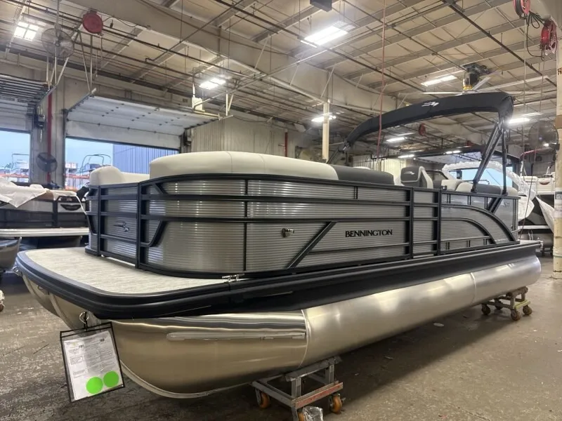 Slide: The Image of A Bennington 22 S1 Stern Radius pontoon boat is in a warehouse. It features a modern design. - 4