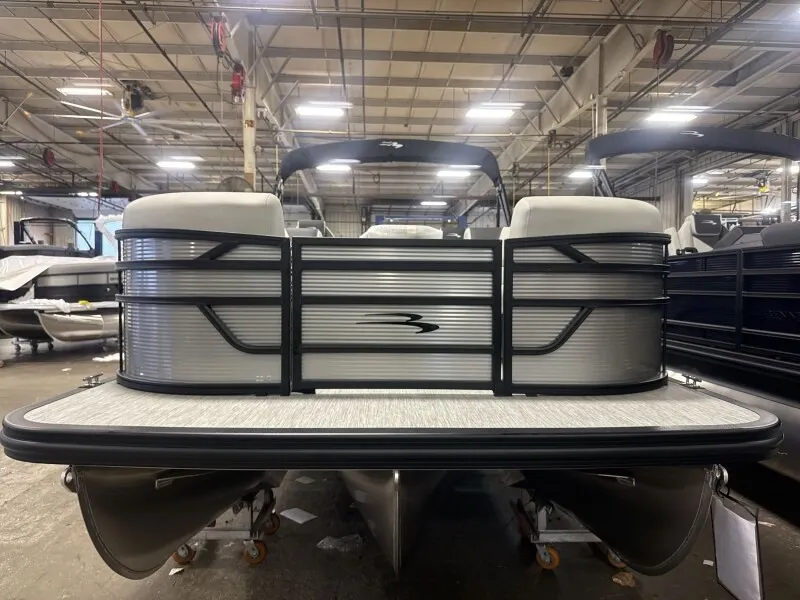 Slide: The Image of A Bennington 22 S1 Stern Radius pontoon boat in a warehouse, featuring a modern design with gray accents. - 3