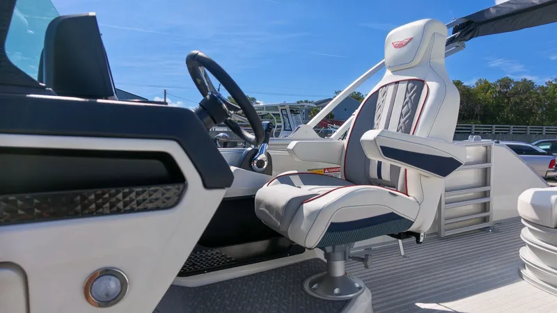 Slide: The Image of The image shows the helm of a 2027 Bennington 22 M Swingback with a cushioned captain's chair. - 22
