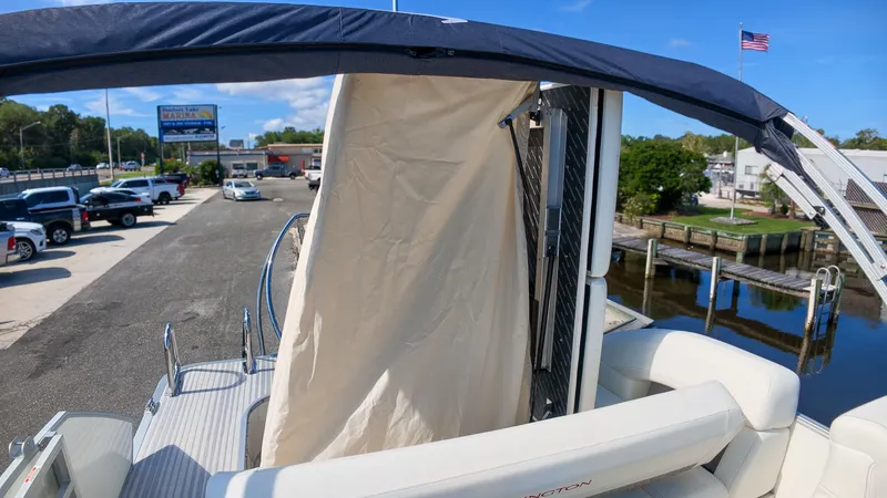 Slide: The Image of The image shows a 2027 Bennington 22 M Swingback boat with a sunshade and white seating. - 26