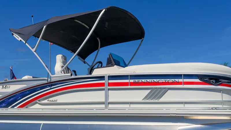 The Image of The image shows a 2027 Bennington 22 M Swingback boat with a black sunshade. - 1