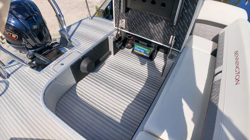 Slide: The Image of The image shows the interior of a 2027 Bennington 22 M Swingback boat with an engine and seating area. - 25