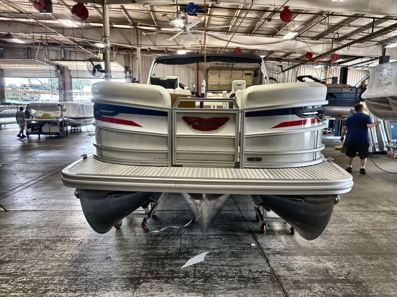 Slide: The Image of A 2027 Bennington 22 M Swingback pontoon boat in a workshop. It features a modern design. - 2