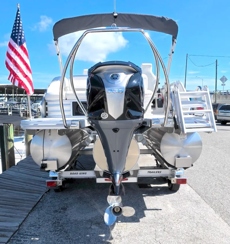 Slide: The Image of A 2027 Bennington 22 M Swingback on a trailer, with an American flag in the background. - 5