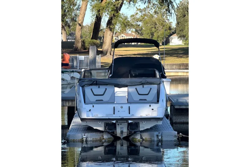 Slide: The Image of 2023 Yamaha Boats SX220 docked at a marina, rear view. - 4