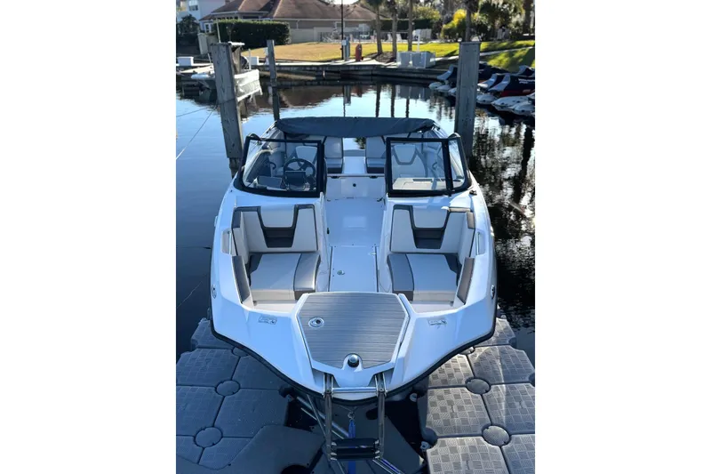 Slide: The Image of 2023 Yamaha Boats SX220 docked, showcasing sleek design and spacious seating. - 5
