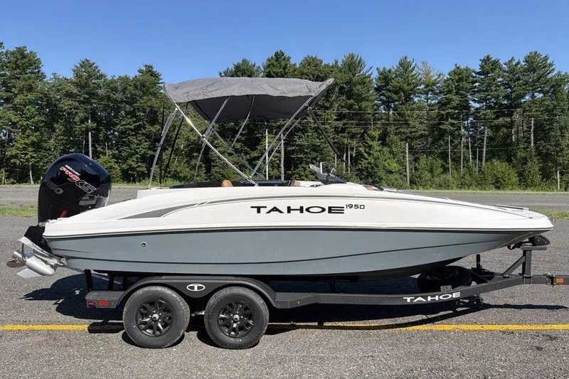The Image of 2026 Tahoe 1950 boat on trailer, parked outdoors with trees in background. - 0