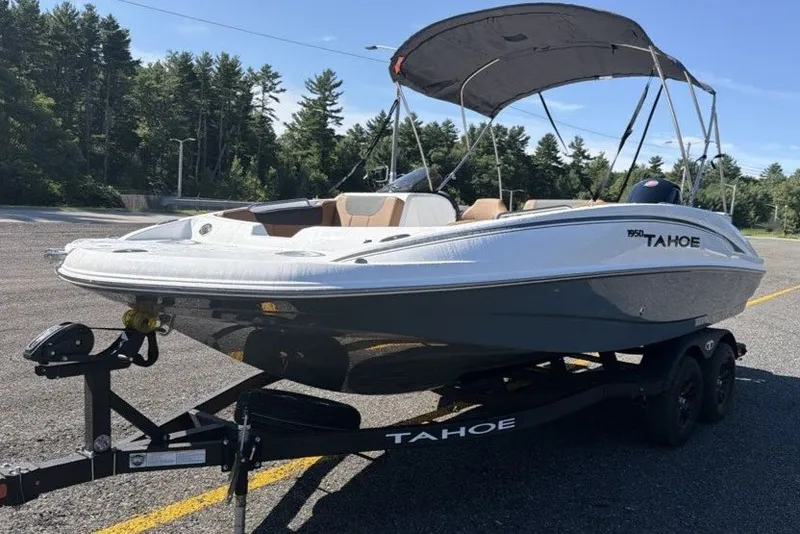 Slide: The Image of 2026 Tahoe 1950 boat on trailer in parking lot, surrounded by trees. - 2