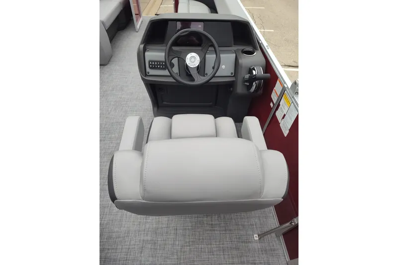 Slide: The Image of 2026 Sun Tracker Party Barge 18 DLX helm with gray captain's chair and steering wheel. - 79