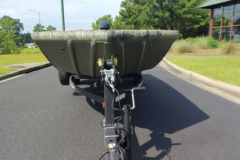 Slide: The Image of 2026 Tracker Grizzly 1650 T Prairie Wings Edition boat on trailer, parked on asphalt road. - 6