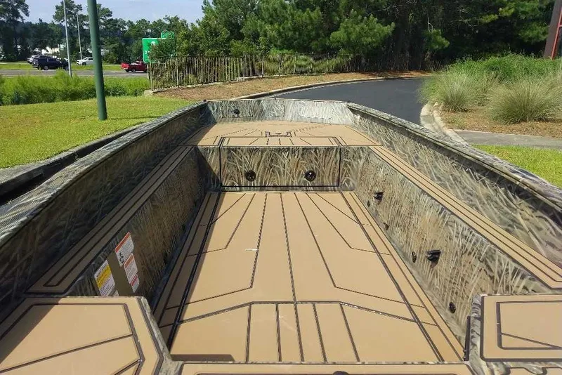 Slide: The Image of 2026 Tracker Grizzly 1650 T Prairie Wings Edition boat with camo design, parked outdoors. - 2