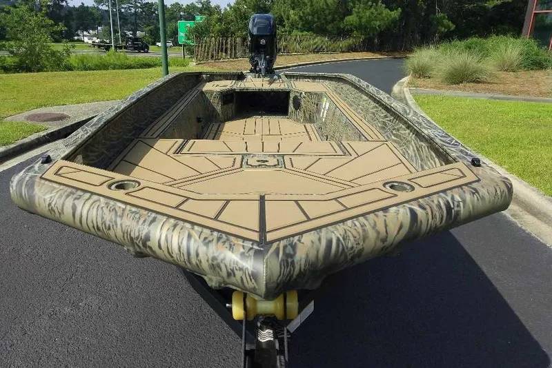 Slide: The Image of 2026 Tracker Grizzly 1650 T Prairie Wings Edition boat with camouflage design on a road. - 5
