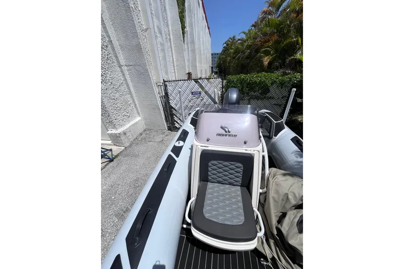 Slide: The Image of 2024 Highfield Sport 520 boat with sleek seating and modern design, parked outdoors. - 20
