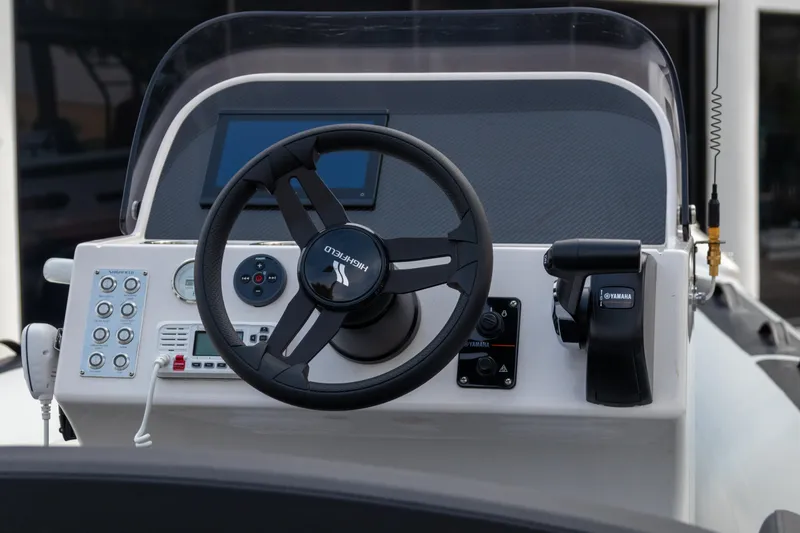Slide: The Image of 2024 Highfield Sport 520 boat dashboard with steering wheel and control panel. - 13