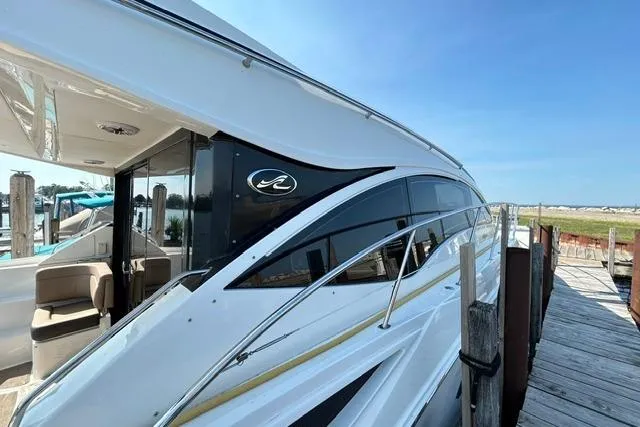 Slide: The Image of 2017 Sea Ray Sundancer 400 yacht docked, showcasing sleek design and luxurious seating. - 3