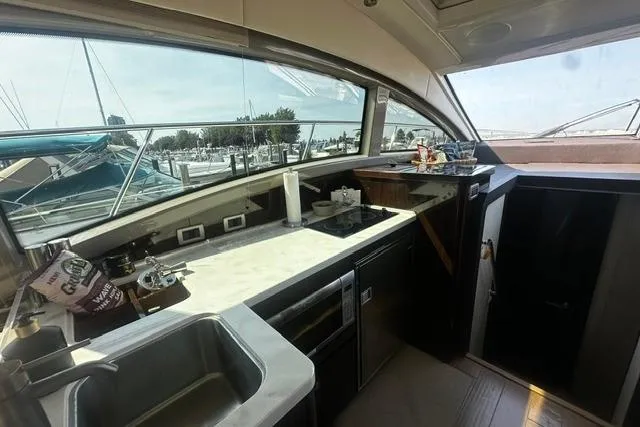 Slide: The Image of Interior of 2017 Sea Ray Sundancer 400 yacht kitchen with modern amenities and marina view. - 16
