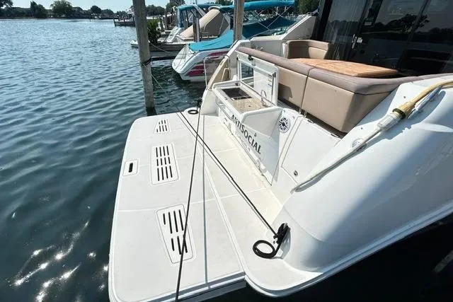 Slide: The Image of 2017 Sea Ray Sundancer 400 yacht docked, featuring spacious swim platform and seating area. - 8