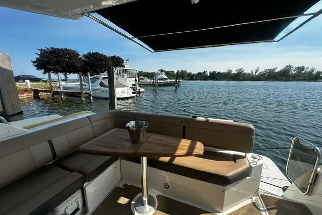 Slide: The Image of 2017 Sea Ray Sundancer 400 yacht with shaded seating area overlooking a serene marina. - 13