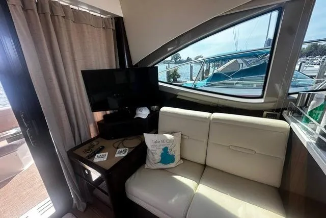 Slide: The Image of Interior of 2017 Sea Ray Sundancer 400 yacht with sofa, TV, and marina view. - 17