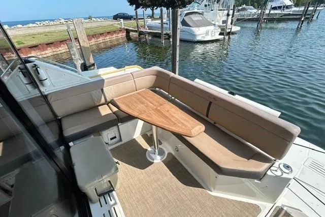 Slide: The Image of 2017 Sea Ray Sundancer 400 yacht with outdoor seating and wooden table by the water. - 9