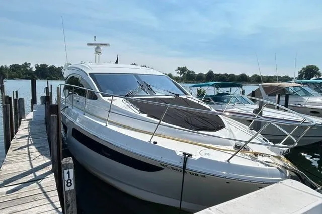 Slide: The Image of 2017 Sea Ray Sundancer 400 yacht docked at a marina on a sunny day. - 2
