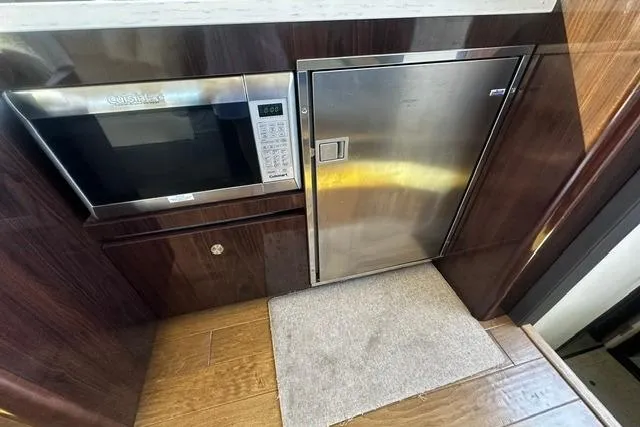 Slide: The Image of 2017 Sea Ray Sundancer 400 yacht kitchen with microwave and stainless steel fridge. - 29