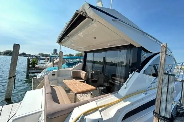 Slide: The Image of 2017 Sea Ray Sundancer 400 yacht docked, featuring spacious outdoor seating and elegant design. - 46
