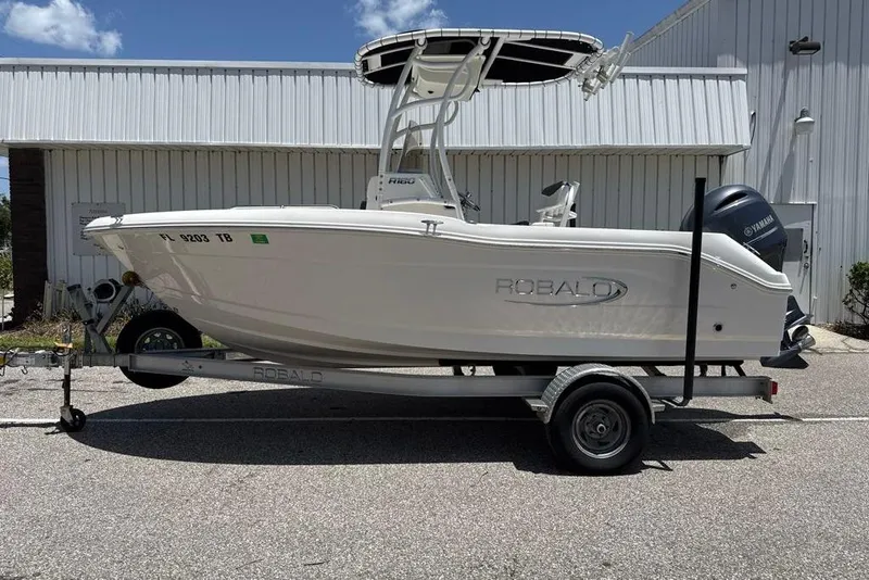Slide: The Image of 2021 Robalo R180 Center Console boat on trailer, parked outdoors. - 0