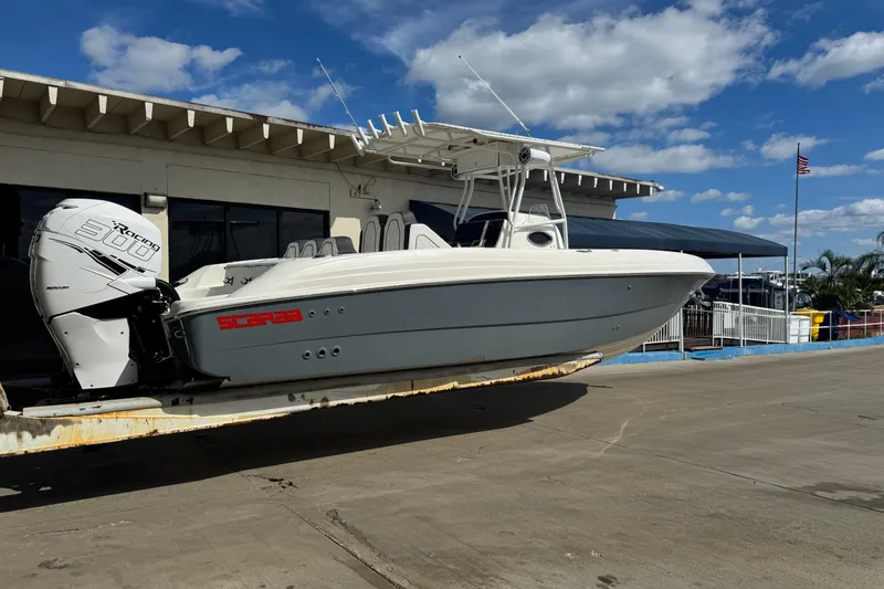 Slide: The Image of 2001 Wellcraft 29 Scarab boat with Mercury engine on a trailer, under a blue sky. - 2