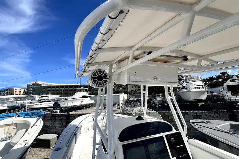 Slide: The Image of 2001 Wellcraft 29 Scarab boat with T-top and speaker, docked under clear blue sky. - 68