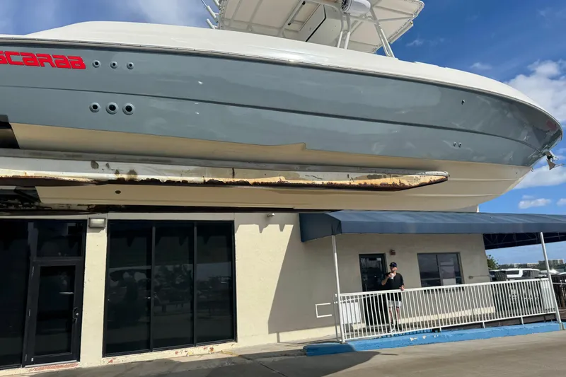 Slide: The Image of 2001 Wellcraft 29 Scarab boat displayed above a building under a clear blue sky. - 4