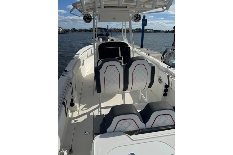 Slide: The Image of 2001 Wellcraft 29 Scarab boat interior with stylish seating, docked by the water. - 5