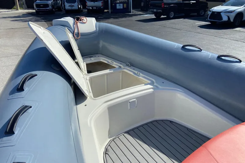 Slide: The Image of 2019 Brig Eagle 650 inflatable boat with open storage compartments, parked outdoors. - 15