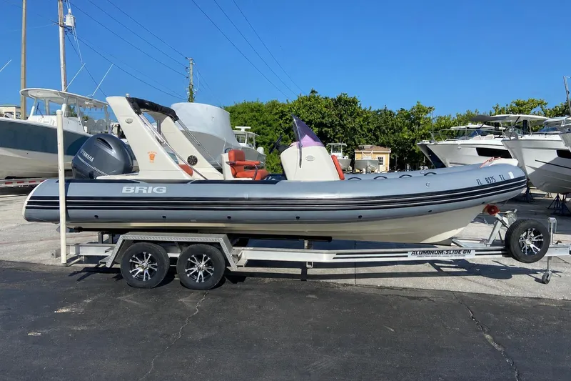Slide: The Image of 2019 Brig Eagle 650 boat on trailer, parked in marina with other boats. - 1