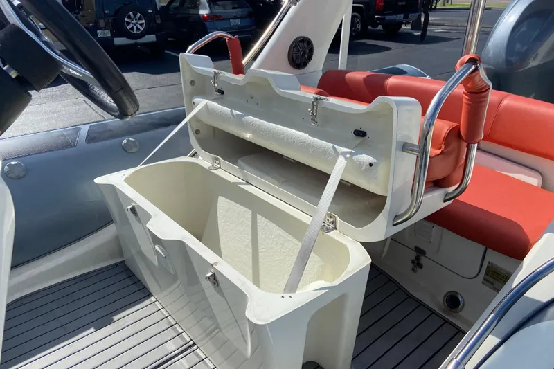 Slide: The Image of 2019 Brig Eagle 650 boat interior with open storage compartment and red seating. - 11