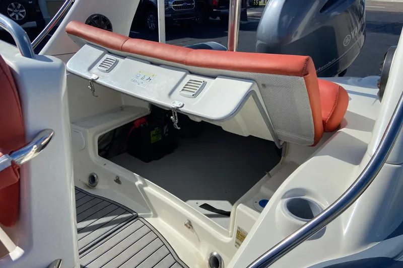 Slide: The Image of 2019 Brig Eagle 650 boat interior with open storage compartment and red seating. - 7
