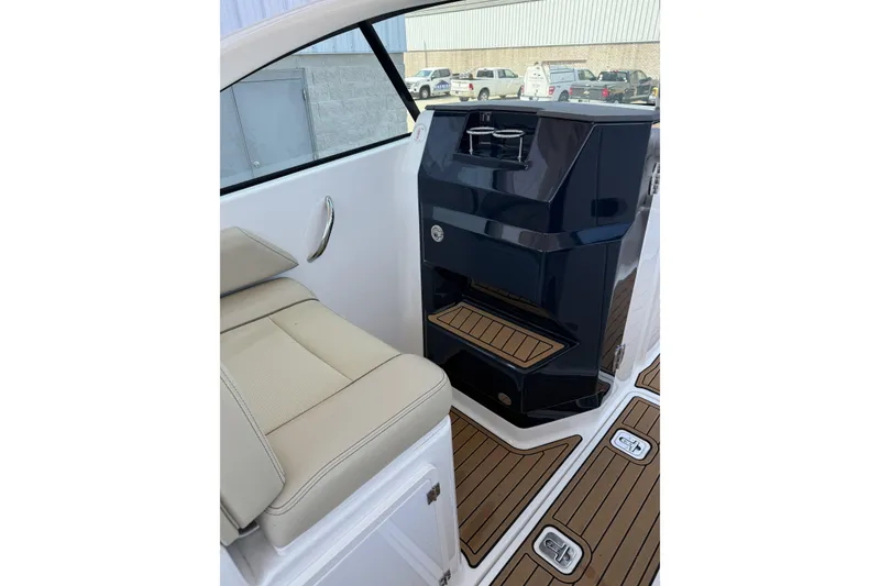 Slide: The Image of 2021 Pursuit DC 235 Dual Console interior with beige seating and sleek black console. - 5