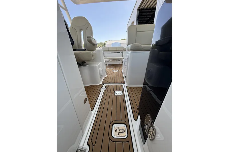 Slide: The Image of 2021 Pursuit DC 235 Dual Console boat interior with teak flooring and comfortable seating. - 6