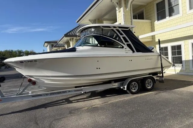Slide: The Image of 2021 Pursuit DC 235 Dual Console boat on trailer, parked near a building. - 16
