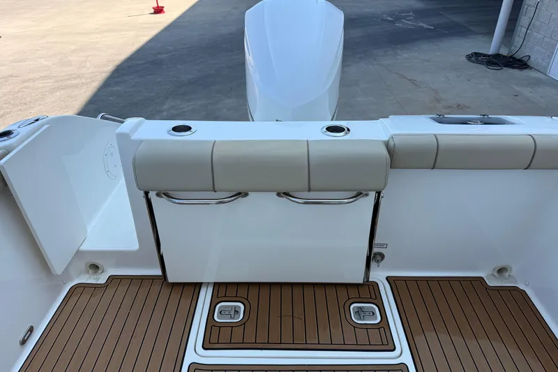 Slide: The Image of 2021 Pursuit DC 235 Dual Console boat interior with teak flooring and cushioned seating. - 12