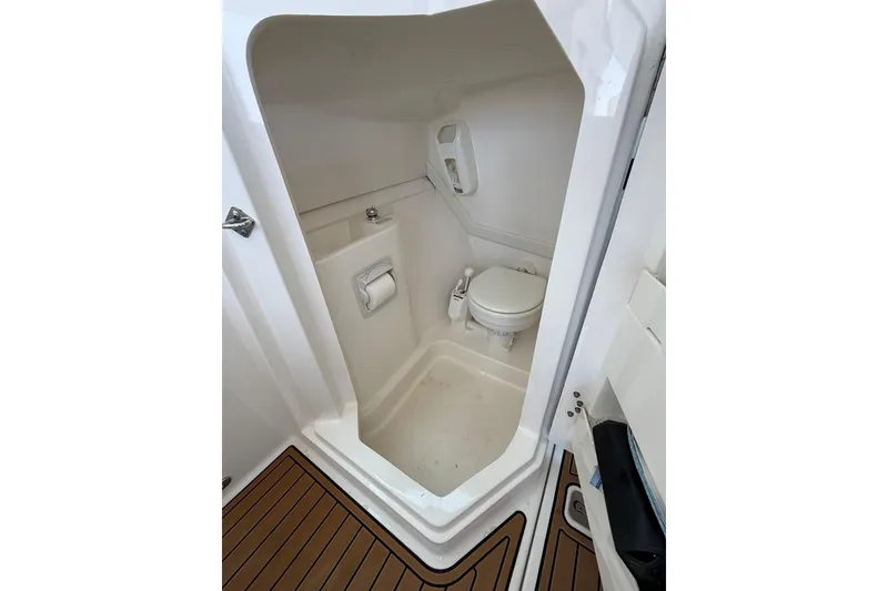 Slide: The Image of 2021 Pursuit DC 235 Dual Console boat interior bathroom with toilet and sink. - 14