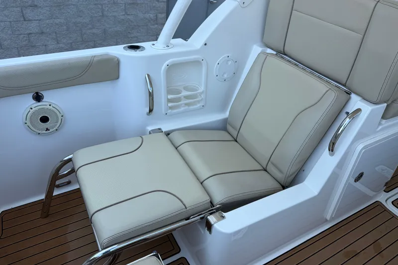 Slide: The Image of 2021 Pursuit DC 235 Dual Console boat seat with beige upholstery and cup holders. - 9