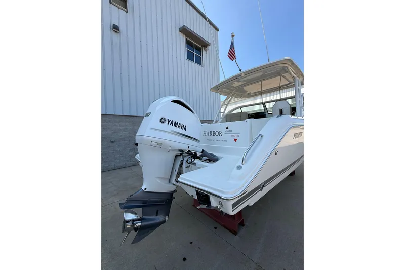 Slide: The Image of 2021 Pursuit DC 235 Dual Console boat with Yamaha outboard motor, docked near a building. - 3