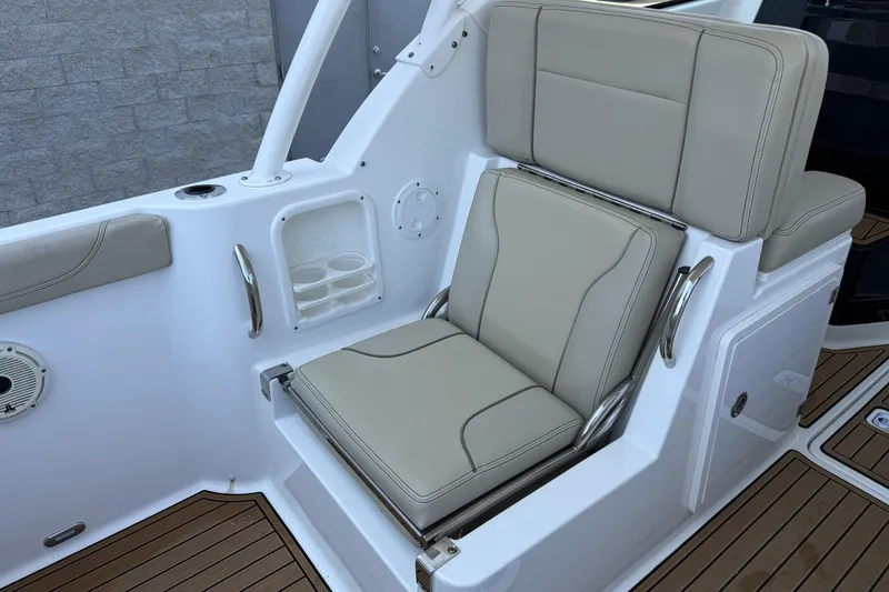 Slide: The Image of 2021 Pursuit DC 235 Dual Console boat seat with beige upholstery and cup holders. - 8