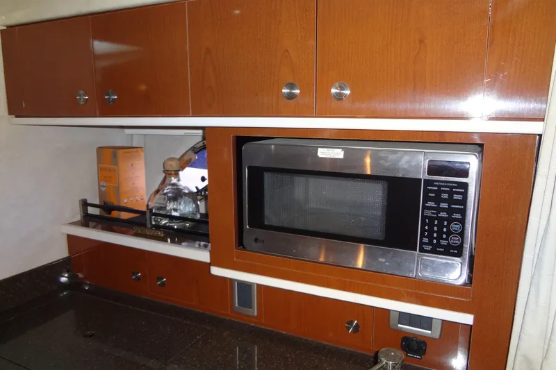 Slide: The Image of 2013 Sea Ray Sundancer 330 interior kitchen with microwave and wooden cabinets. - 42
