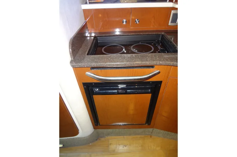 Slide: The Image of 2013 Sea Ray Sundancer 330 galley with stove and compact refrigerator. - 44