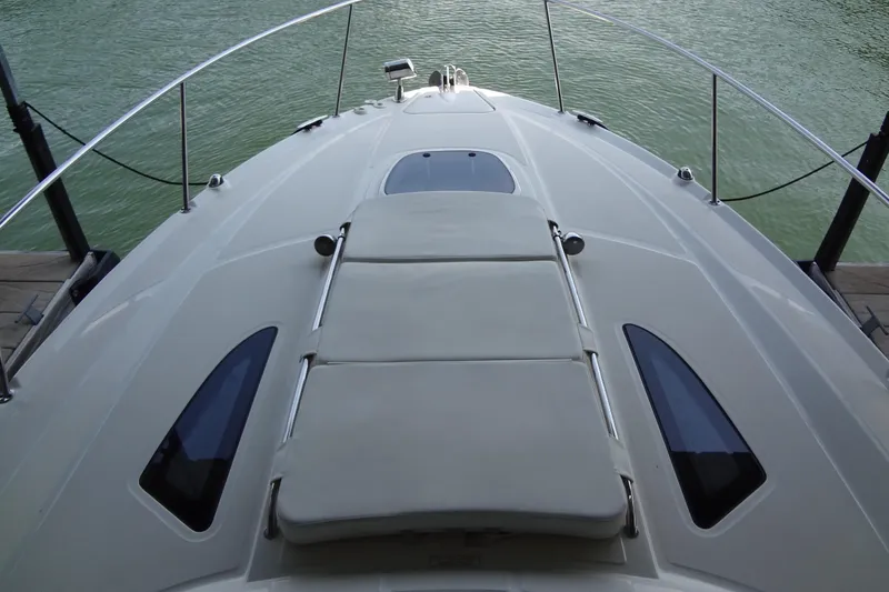 Slide: The Image of 2013 Sea Ray Sundancer 330 boat deck with sunpad, docked on calm water. - 33