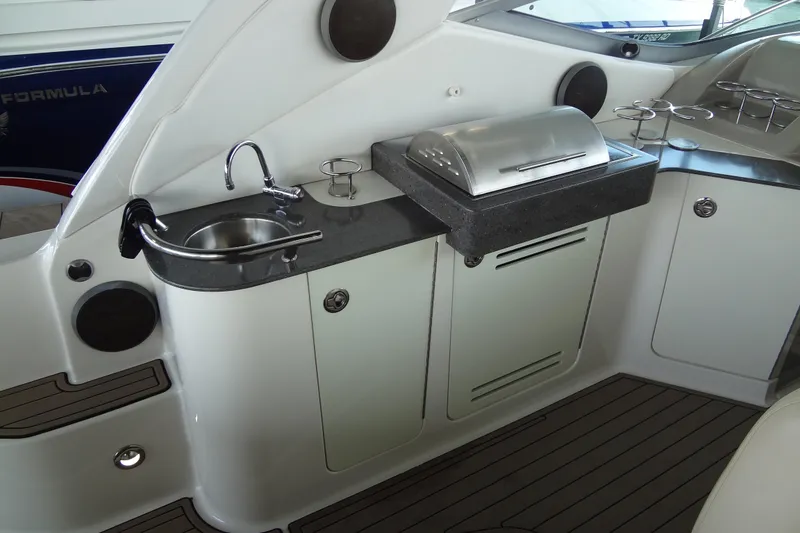 Slide: The Image of 2013 Sea Ray Sundancer 330 yacht kitchenette with sink, grill, and storage cabinets. - 22