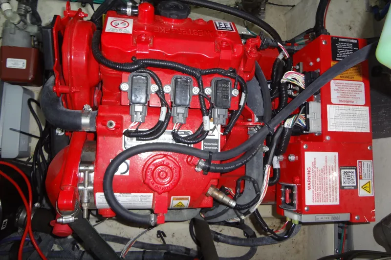 Slide: The Image of Engine compartment of a 2013 Sea Ray Sundancer 330, featuring a red engine and wiring. - 58
